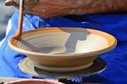 Craft pottery being painted on a lathe