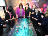Commissioner with children playing the eco-ocean game from the JRC at the EU Stand