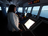 Commissioner looking at the open sea from the doorway (wheelhouse) of a boat driving simulator, during her visit to the Fisheries and Marine Institute of Newfoundland
