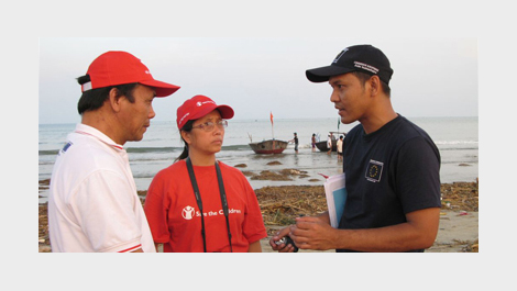 Three humanitarian workers talking together © EU