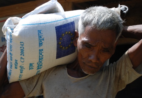 Мъж от Бангладеш носи на рамо торба с ориз, върху която е изобразено логото на ЕС © ЕС