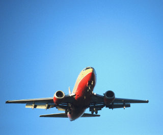 Airplane in blue sky © Stockbyte/John Foxx
