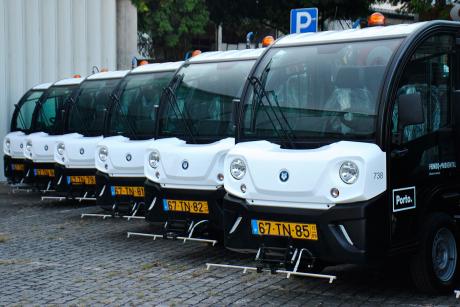 The image shows a row of parked electric street sweper cars, from the city of Porto 