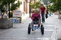 Kvinde på firehjulet cykel i by i Portugal