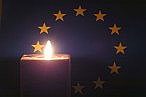 Candela accesa sullo sfondo della bandiera dell’UE.