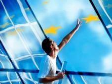 Uomo su una scala che allunga le braccia verso le stelle della bandiera dell'UE