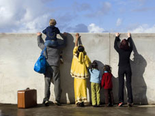 Migrant family trying to look beyond wall