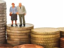 Un couple de personnes âgées se tenant debout sur une pile de pièces de monnaie.