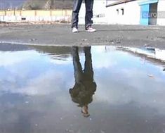 Man standing over a puddle in industrial area