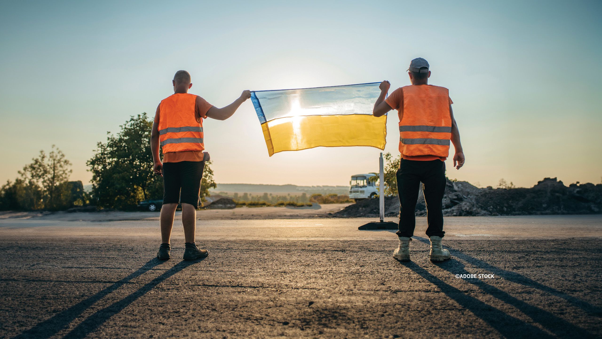 Two construction workers holding a Ukrainian flag