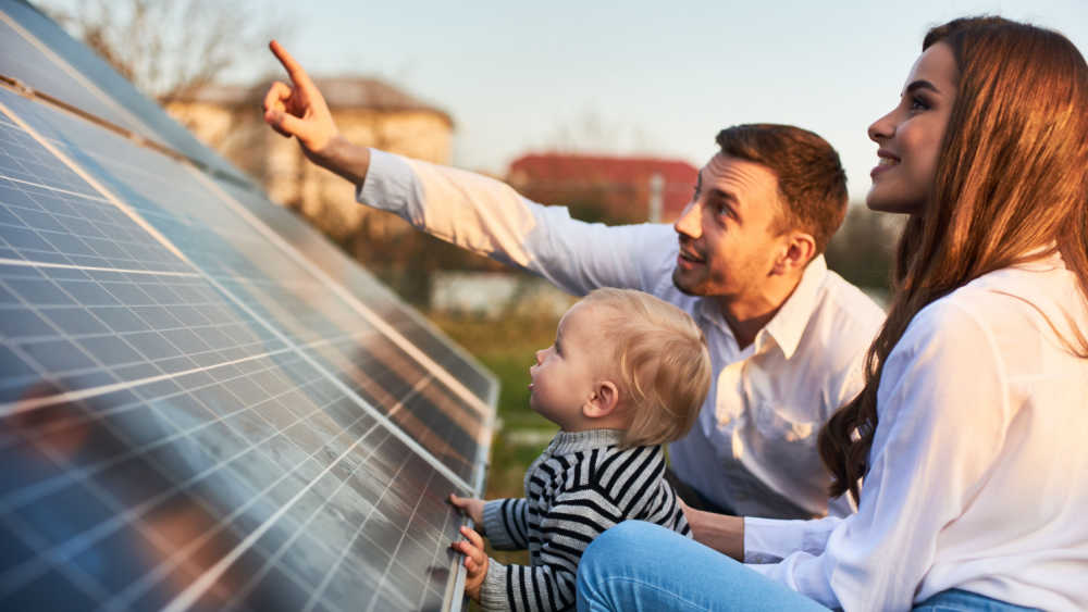 family looking at solar panel.