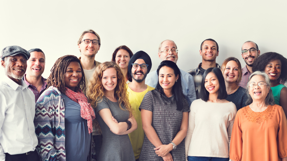 A group of people of diverse ethnic background and age pose for a photo.