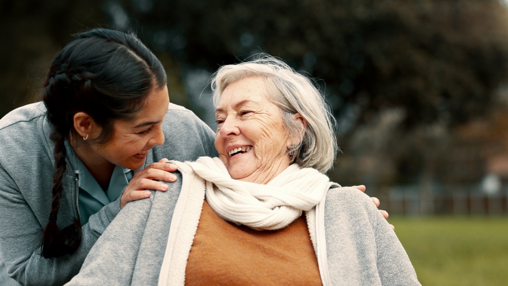 An older and a younger woman smiling.