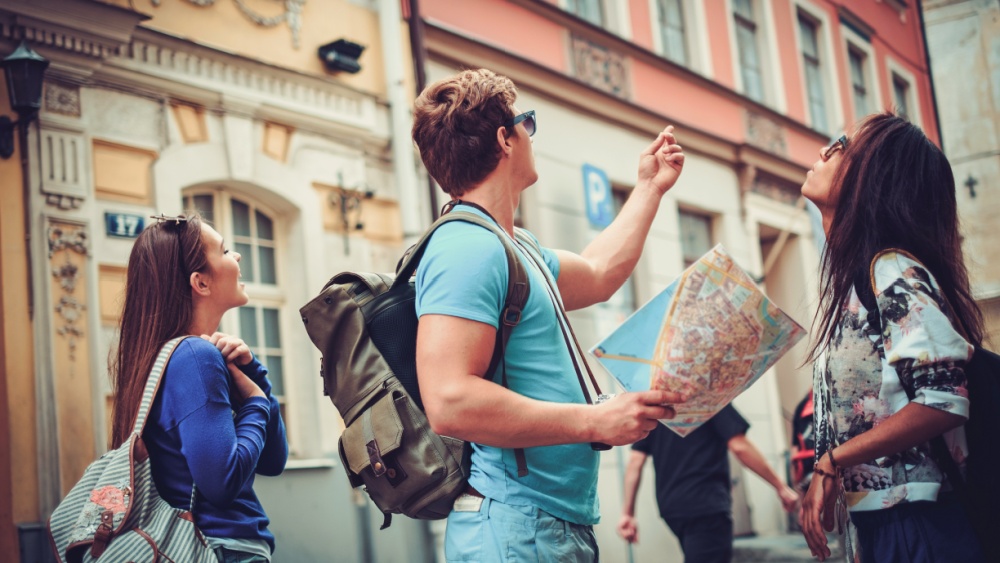 Man with a map in the hand pointing in a direction.