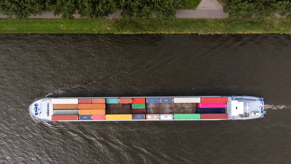 A transport ship filled with containers is sailing on the water