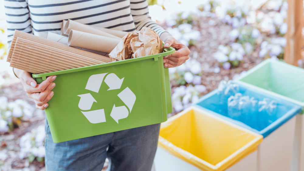 Woman sorting paper waste to recycling bin