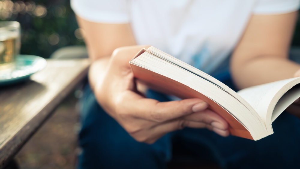 A person is sitting with a book in their hands