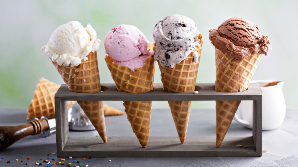 An ice cream holder is holding 4 ice creams in cones