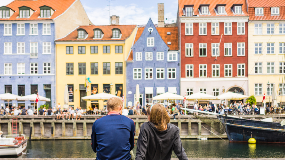 Two people sitting by the canal in Copenhagen.