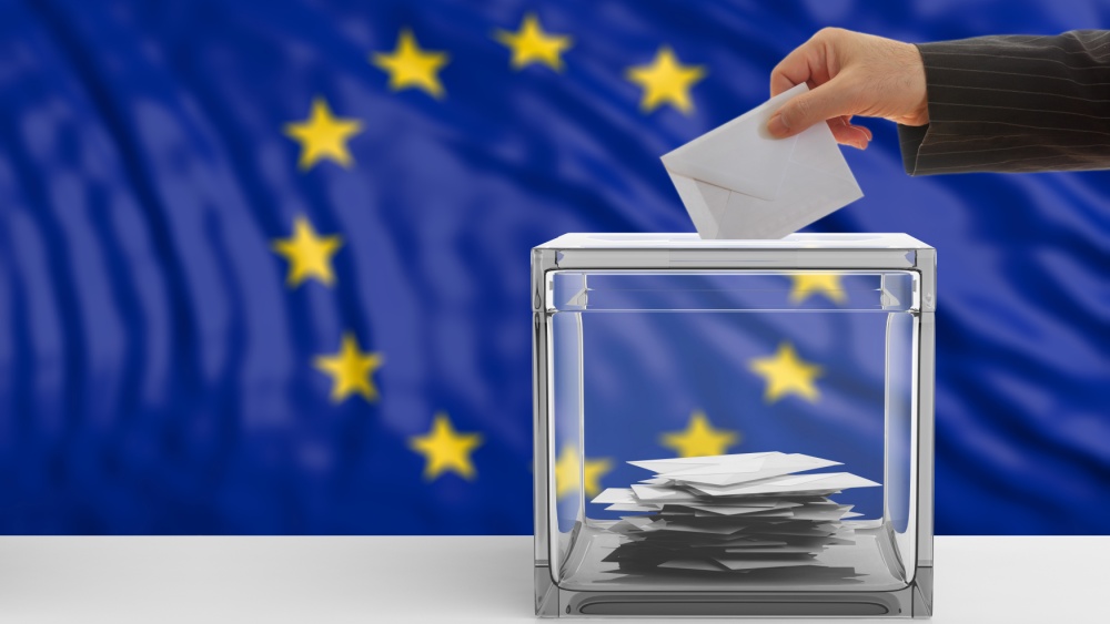 A hand casting a vote in front of an EU flag.