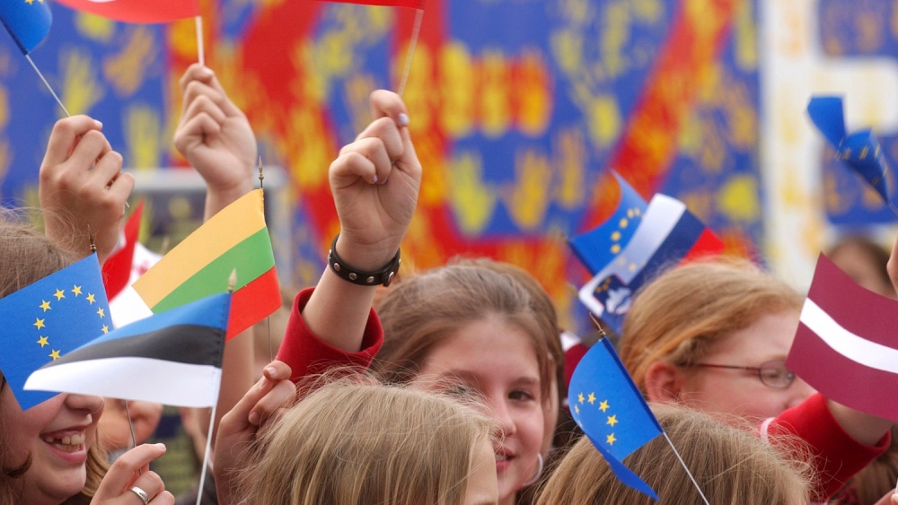 Young people waving EU flags.