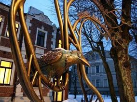 Railings with iron raven and buildings in the background
