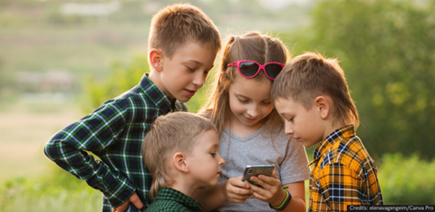 Group of children looking at content on a mobile phone