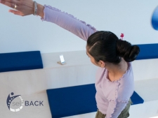 woman standing using selfBACK app supporting back pain therapy