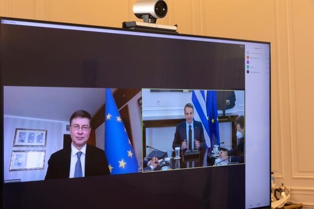 Greek Prime Minister Kyriakos Mitsotakis, right, speaks with Valdis Dombrovskis, during a tele-conference © European Union