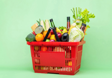 A red busket filled with fruits, vegetables, canned goods, ©Adobe Stock