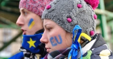 Two ukranian women holding EU flags and facepaint that reads "EU"