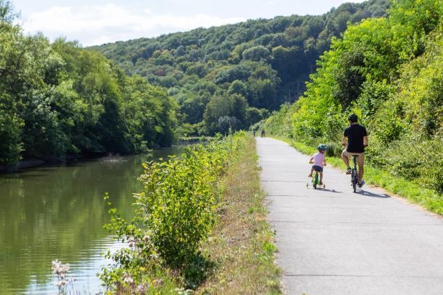 Father with his son riding bike during summer close to a river