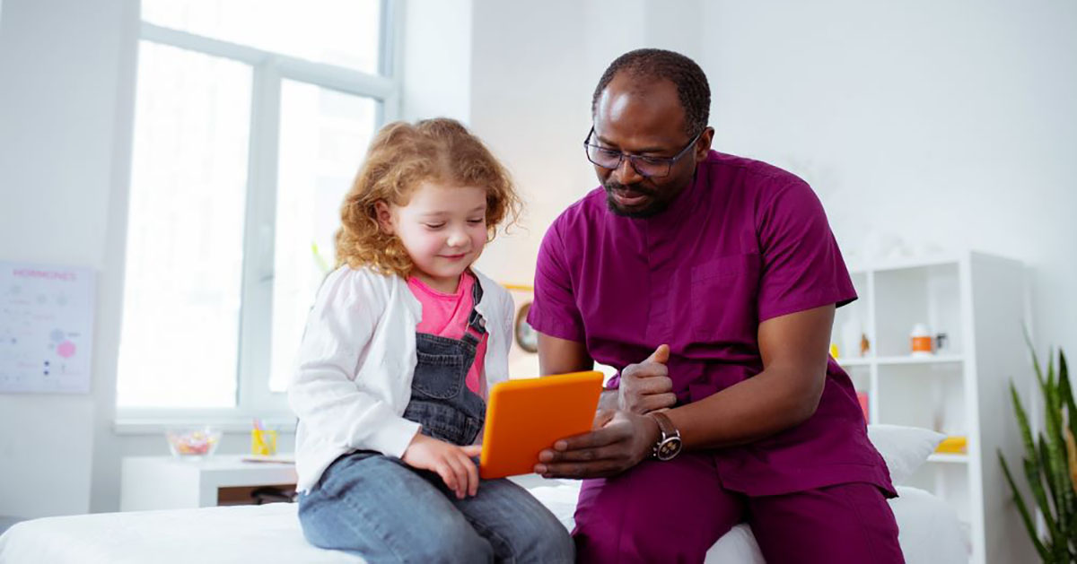Nurse in a hospital showing a tablet to a children