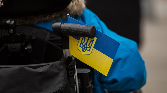 Back picture of a persons in wheelchair with an Ukrainian flag
