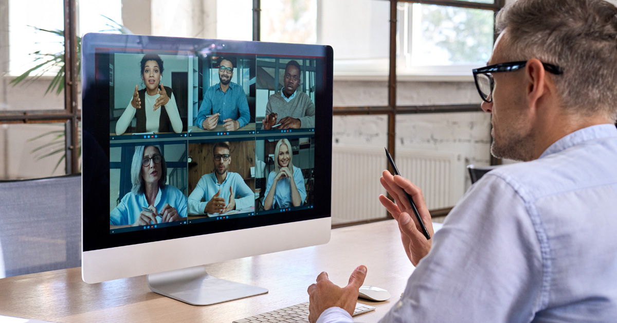 Corporate leader manager leading videoconference with diverse team business people having digital group video conference call working in office at online virtual meeting on pc computer. Over shoulder: