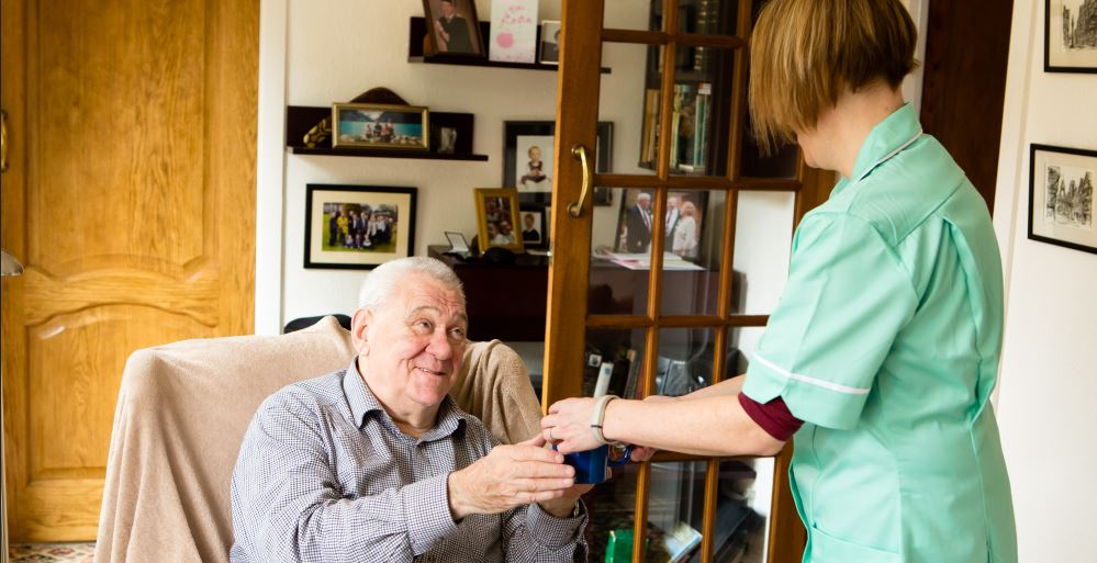 Long-term care for elderly people: a carer looking after an older man in his home