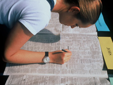 Frau streicht Stellenangebote in einer Zeitung an © EU