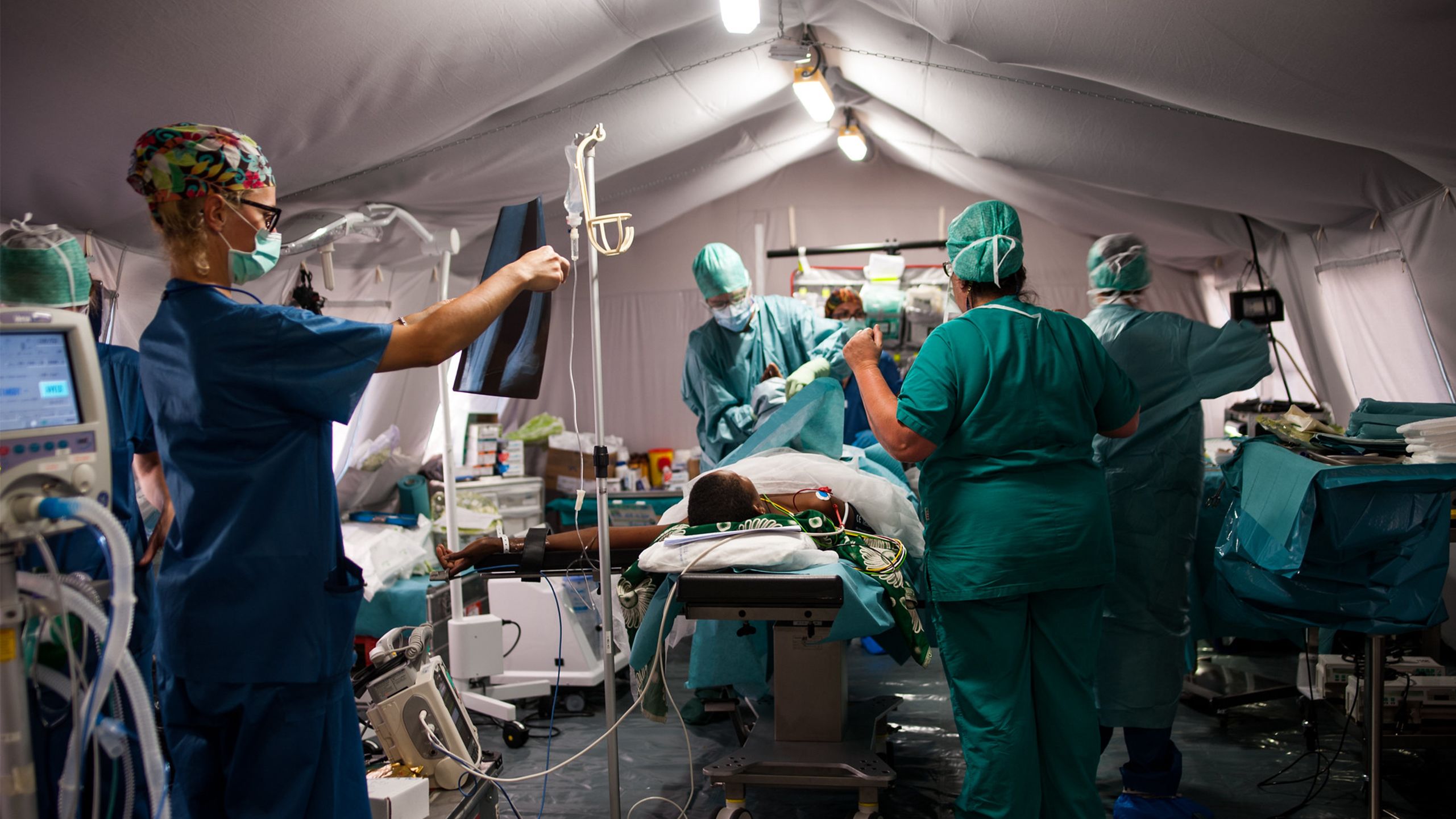 An Emergency Medical Team treats a patient in a field hospital.